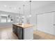 Kitchen featuring an island with seating, stainless dishwasher, sink, and granite countertop under modern lighting at 5030 Caspian St, St Cloud, FL 34771