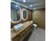 A modern bathroom features herringbone wood countertop and dual illuminated mirrors at 610 Cypress Ave, Orange City, FL 32763
