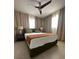 Comfortable bedroom with a neutral color palette, soft lighting, and tiled floors for a serene retreat at 610 Cypress Ave, Orange City, FL 32763