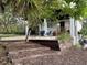 A charming home features a private outdoor seating area with a grill and mature foliage at 610 Cypress Ave, Orange City, FL 32763
