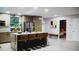 Bright, modern kitchen with an island, waterfall countertops, stainless appliances, and natural light from skylights and green plants at 610 Cypress Ave, Orange City, FL 32763