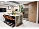 Modern kitchen featuring an island with a waterfall countertop and seating for four, stainless steel appliances, and wood cabinetry at 610 Cypress Ave, Orange City, FL 32763