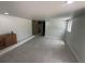 An empty living room with gray tiled floors features abundant natural lighting and access to a kitchenette at 610 Cypress Ave, Orange City, FL 32763