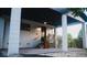 A home's porch is supported by classic columns and features modern wood slat accents and manicured landscaping at 610 Cypress Ave, Orange City, FL 32763