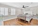 Bright bedroom with wood floors, ceiling fan, and bench seating at the foot of the bed at 614 Mockingbird Ln, Altamonte Springs, FL 32714
