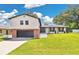 Charming two-story home with a brick and gray two-car garage and beautifully manicured lawn at 614 Mockingbird Ln, Altamonte Springs, FL 32714