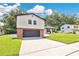 Charming two-story home with a brick and gray two-car garage and beautifully manicured lawn at 614 Mockingbird Ln, Altamonte Springs, FL 32714
