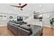 Spacious living room featuring hardwood floors, ceiling fans, a large gray couch, and double front doors at 614 Mockingbird Ln, Altamonte Springs, FL 32714