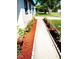 Landscaped walkway leading to a freshly painted home with flower beds at 6366 Forecastle Ct, Orlando, FL 32807