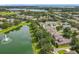 Breathtaking aerial view of homes near a lake with a fountain, surrounded by lush greenery and serene water at 6971 Tettenhall Ln, Windermere, FL 34786