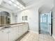Bathroom featuring double sink vanity, tiled floors, and a glass door shower at 6971 Tettenhall Ln, Windermere, FL 34786