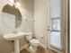 Bathroom featuring a pedestal sink, toilet, mirror, tiled floors, and a door to the outside at 6971 Tettenhall Ln, Windermere, FL 34786