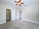 Carpeted bedroom includes a ceiling fan, closet, and a doorway to another room at 6971 Tettenhall Ln, Windermere, FL 34786