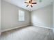 This bedroom features neutral walls, carpet flooring, a ceiling fan, and a bright window at 6971 Tettenhall Ln, Windermere, FL 34786