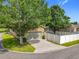 Inviting home featuring mature trees, a well-maintained lawn, and a paved driveway at 6971 Tettenhall Ln, Windermere, FL 34786