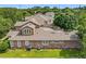 Rear view of a two-story home showcasing a lush lawn, several windows, and exterior features at 6971 Tettenhall Ln, Windermere, FL 34786