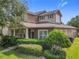 Beautifully landscaped two-story home featuring a welcoming porch and lush greenery enhancing its attractive facade at 6971 Tettenhall Ln, Windermere, FL 34786