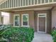 Exterior showcasing a covered front porch, the front door, and well-maintained surrounding landscaping at 6971 Tettenhall Ln, Windermere, FL 34786