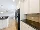 The kitchen features white cabinets, granite countertops, and stainless steel appliances at 6971 Tettenhall Ln, Windermere, FL 34786
