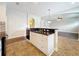 Kitchen island features white cabinets, tile floors, and a stainless steel sink at 6971 Tettenhall Ln, Windermere, FL 34786
