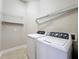 Bright laundry room features a washer, dryer, and built-in shelving for convenient storage at 6971 Tettenhall Ln, Windermere, FL 34786