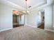 Open living room featuring carpet floors, archways, and elegant lighting at 6971 Tettenhall Ln, Windermere, FL 34786