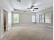 Large primary bedroom with carpet, ceiling fan, and lots of windows at 6971 Tettenhall Ln, Windermere, FL 34786