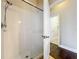 This bathroom has a shower with white tiling and a glass door plus wood floors outside the shower at 6971 Tettenhall Ln, Windermere, FL 34786