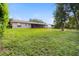 Vast backyard with a healthy lawn, mature trees, and the rear of the house at 7022 Talbot Dr, Orlando, FL 32819