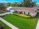 Landscaped front yard featuring green lawn, bushes, and chairs on the front porch at 7022 Talbot Dr, Orlando, FL 32819