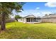 Green backyard featuring a white home with a screened in porch at 745 Ashley Ln, Orlando, FL 32825
