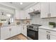 Modern kitchen featuring white cabinets, stainless steel appliances, and a stylish backsplash at 745 Ashley Ln, Orlando, FL 32825
