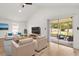 Well-lit living room with vaulted ceilings, neutral furniture, and sliding door to patio at 745 Ashley Ln, Orlando, FL 32825