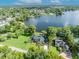 Wide aerial view of the lakefront property with its well-maintained lawn at 7801 Georgeann St, Winter Park, FL 32792