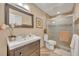 Nicely designed bathroom featuring a shower, dark wood vanity, decorative mirror and attractive wall art at 7801 Georgeann St, Winter Park, FL 32792
