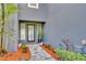Inviting home entrance with glass front door, walkway, and landscaped garden at 7801 Georgeann St, Winter Park, FL 32792