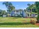 Charming two-story home featuring a well-manicured lawn and tropical landscaping at 7801 Georgeann St, Winter Park, FL 32792