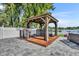 Outdoor gazebo with hot tub and grill on a paved patio, perfect for relaxing by the lake at 7801 Georgeann St, Winter Park, FL 32792