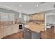 Spacious kitchen features an island, tile backsplash, stainless steel appliances, and light wood cabinets at 7801 Georgeann St, Winter Park, FL 32792