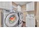 Well-equipped laundry area with modern washer/dryer, storage cabinets, and a convenient utility sink at 7801 Georgeann St, Winter Park, FL 32792
