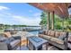 Inviting covered patio features a comfortable seating area, outdoor kitchen and a scenic lake view at 7801 Georgeann St, Winter Park, FL 32792