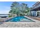 Stunning backyard with a modern pool, picturesque lake view, and an adjacent wooden deck for relaxation at 7801 Georgeann St, Winter Park, FL 32792