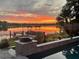 Beautiful waterfront view showcasing a picturesque sunset, a boat, and outdoor decor by the pool at 7801 Georgeann St, Winter Park, FL 32792