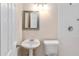 Small bathroom with a pedestal sink, toilet, mirror, and shower with white tile at 8111 Esperanza St, Orlando, FL 32817
