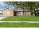 Charming single-story home with a well-manicured lawn and mature trees adding curb appeal at 8111 Esperanza St, Orlando, FL 32817