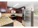 Updated kitchen featuring stainless steel appliances, granite countertops, and dark wood cabinetry at 8111 Esperanza St, Orlando, FL 32817