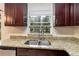 Well-lit kitchen sink with granite countertops and a window view of the outside at 8111 Esperanza St, Orlando, FL 32817