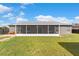 Backyard with a screened-in patio, lush green grass, and privacy fencing at 906 Highland Crest Cir, Lake Wales, FL 33853