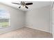 Inviting bedroom featuring neutral carpet, a ceiling fan, and a window for natural light at 906 Highland Crest Cir, Lake Wales, FL 33853