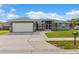 Charming single-story home featuring a gray exterior, well-manicured lawn, and an attached two-car garage at 906 Highland Crest Cir, Lake Wales, FL 33853
